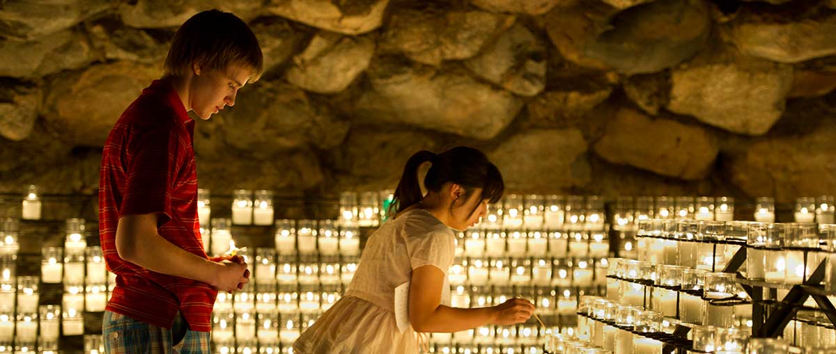 Students lighting candles at the Grotto